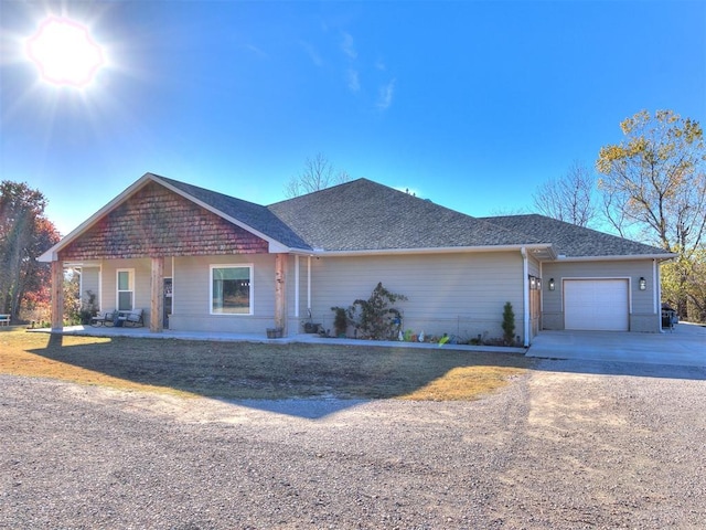 ranch-style house with roof with shingles, driveway, and an attached garage