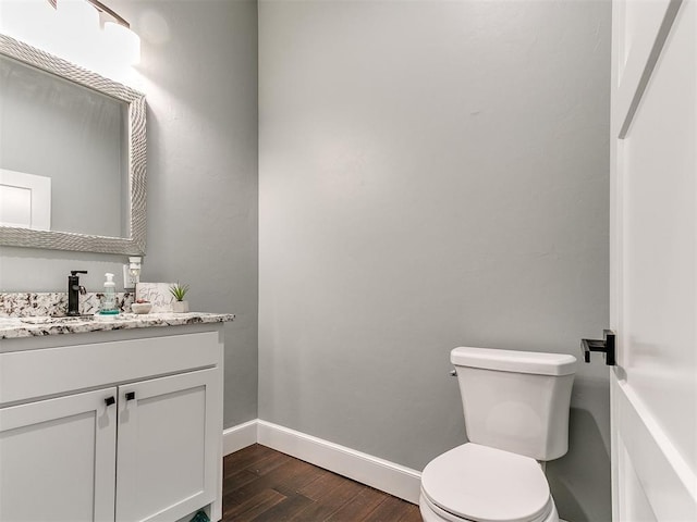 bathroom featuring vanity, wood finished floors, toilet, and baseboards