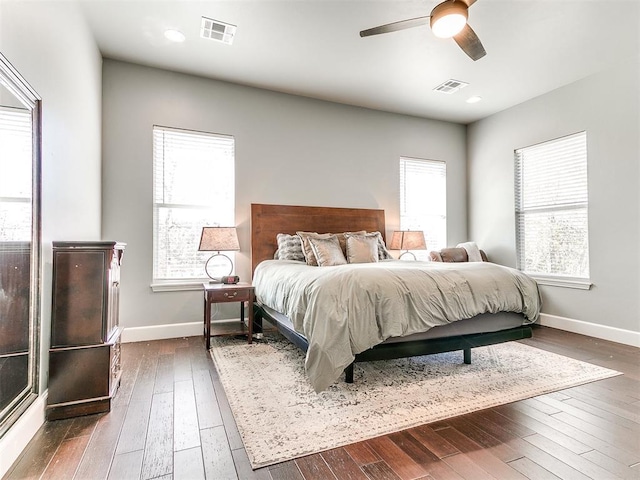 bedroom featuring dark wood-style floors, visible vents, and baseboards