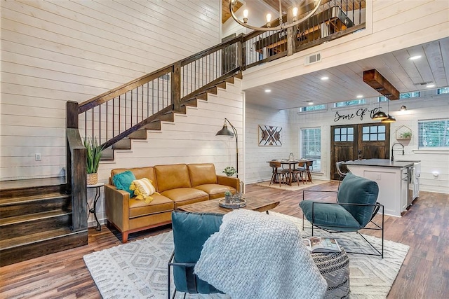 living room featuring wood walls, wooden ceiling, dark wood-type flooring, a high ceiling, and french doors