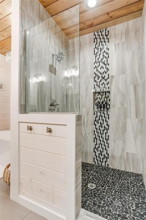 bathroom featuring wood ceiling and tiled shower