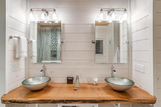 bathroom featuring wood walls and sink