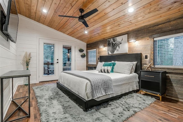 bedroom featuring access to outside, ceiling fan, lofted ceiling, and wood walls