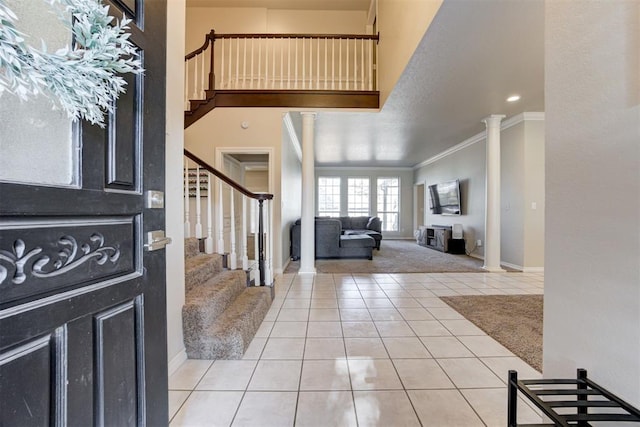 tiled foyer entrance featuring ornate columns and ornamental molding