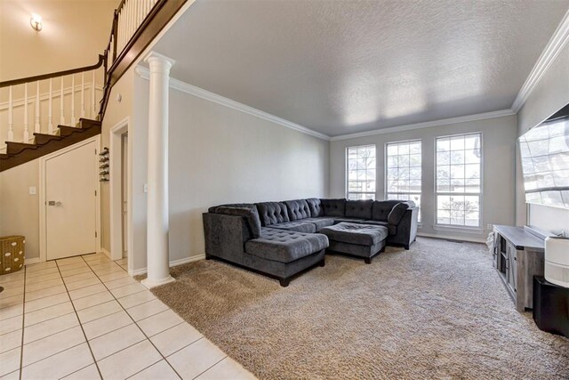 living room featuring light colored carpet, ornamental molding, a textured ceiling, and decorative columns