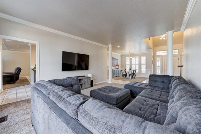 living room featuring carpet, ornate columns, ornamental molding, and an inviting chandelier