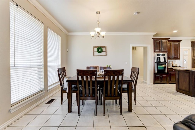 tiled dining area featuring ornamental molding, an inviting chandelier, and a healthy amount of sunlight