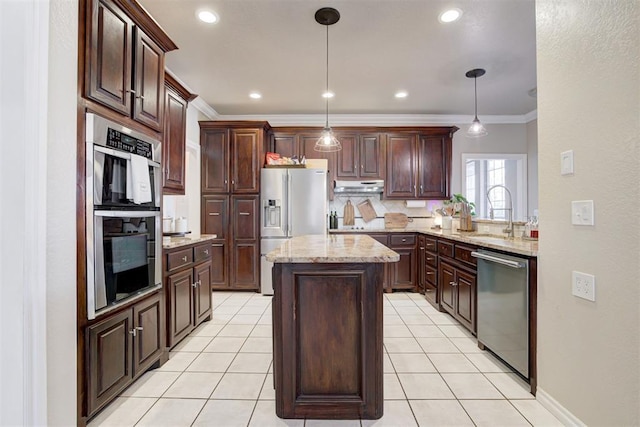 kitchen with sink, a center island, stainless steel appliances, decorative light fixtures, and ornamental molding