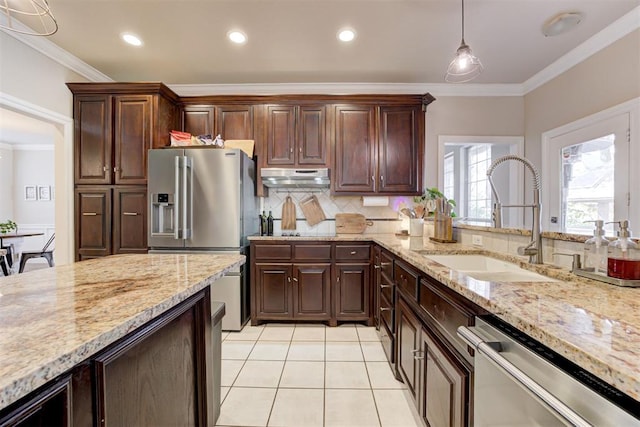 kitchen with decorative backsplash, appliances with stainless steel finishes, crown molding, sink, and pendant lighting