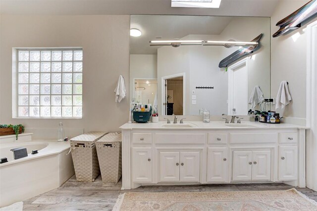 bathroom featuring vanity, a tub, and a wealth of natural light