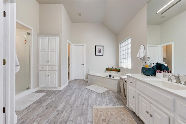 bathroom featuring shower with separate bathtub, vanity, hardwood / wood-style flooring, and lofted ceiling