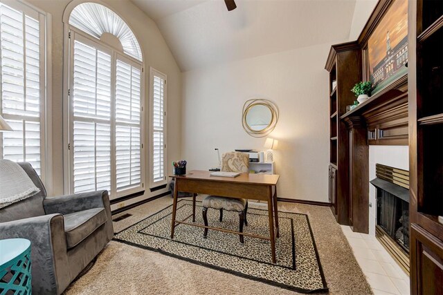 office area featuring a fireplace, vaulted ceiling, and ceiling fan