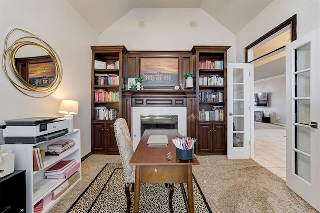 office featuring light colored carpet, french doors, a tile fireplace, and vaulted ceiling