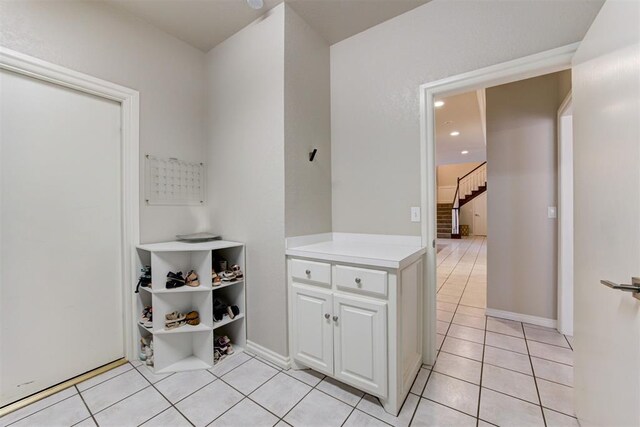 interior space featuring white cabinets and light tile patterned flooring