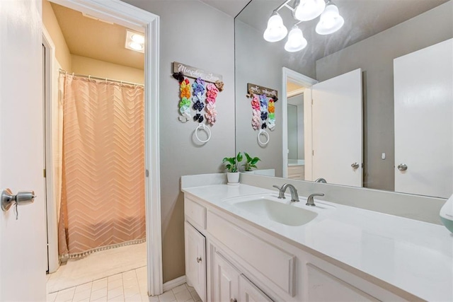 bathroom with a chandelier, vanity, and tile patterned floors