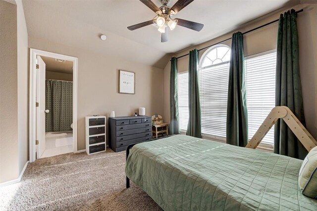 carpeted bedroom with connected bathroom, ceiling fan, and lofted ceiling