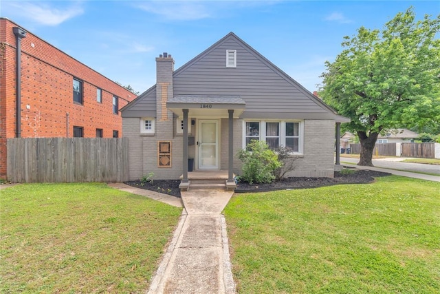 1840 NW 11th St, Oklahoma City, OK 73106 - view of front of home featuring fence, a front yard, and a chimney