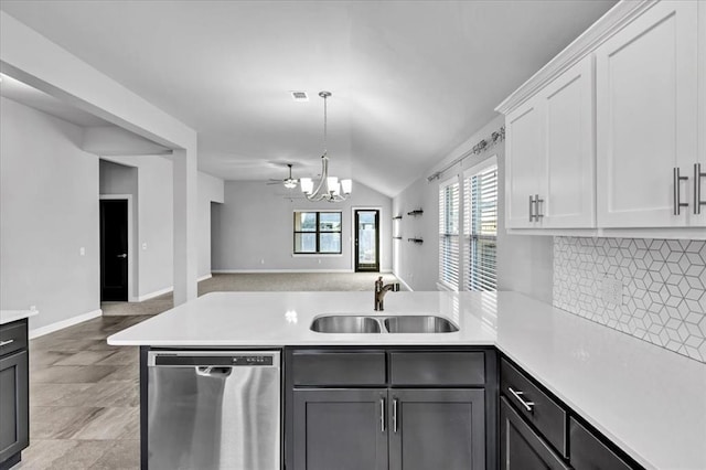 kitchen with dishwasher, sink, a chandelier, vaulted ceiling, and white cabinets