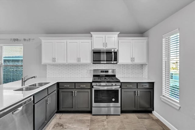 kitchen with white cabinetry, sink, stainless steel appliances, backsplash, and gray cabinets