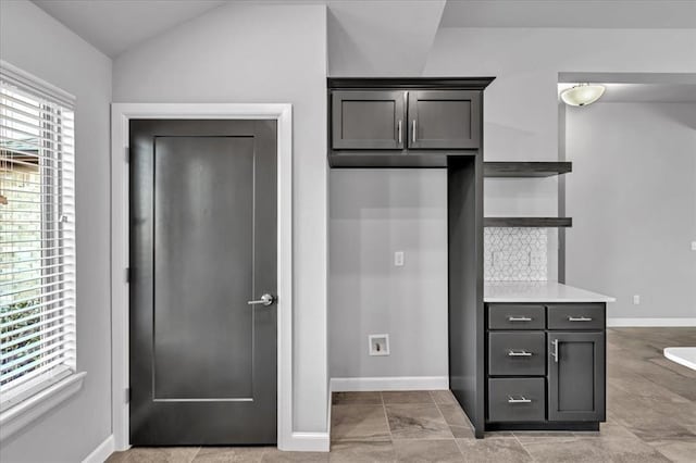 kitchen featuring backsplash and lofted ceiling