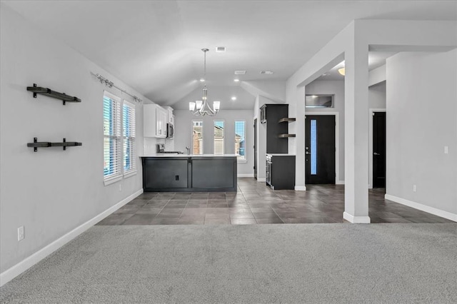 kitchen with white cabinets, dark carpet, and lofted ceiling