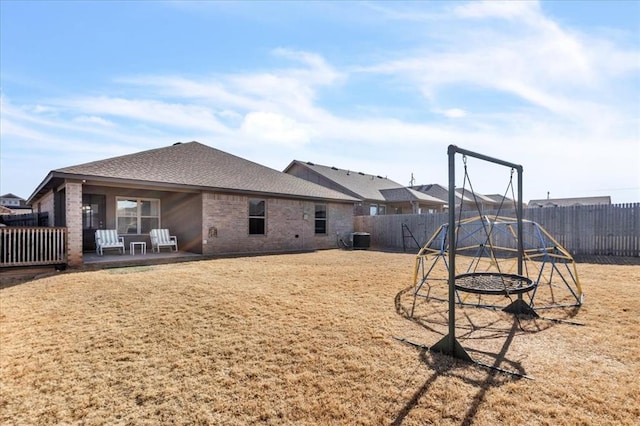 exterior space featuring cooling unit, a playground, a patio, and a yard