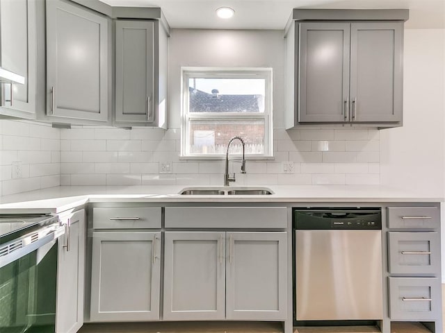 kitchen featuring appliances with stainless steel finishes, backsplash, gray cabinetry, and sink