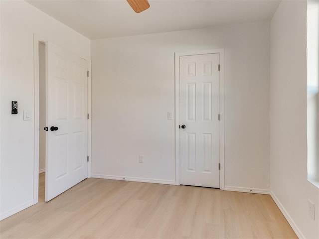 spare room with light wood-type flooring and ceiling fan