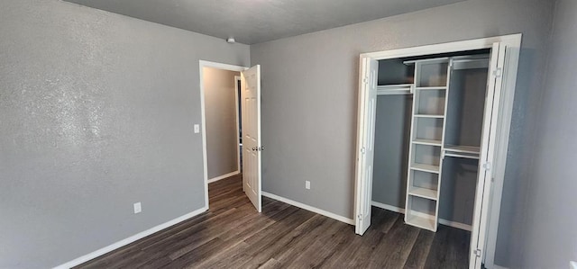 unfurnished bedroom featuring dark hardwood / wood-style flooring and a closet