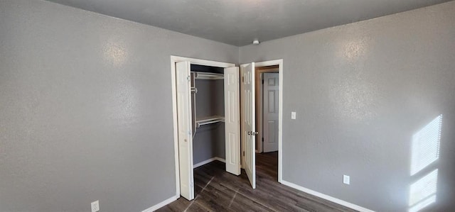 unfurnished bedroom featuring dark hardwood / wood-style floors and a closet