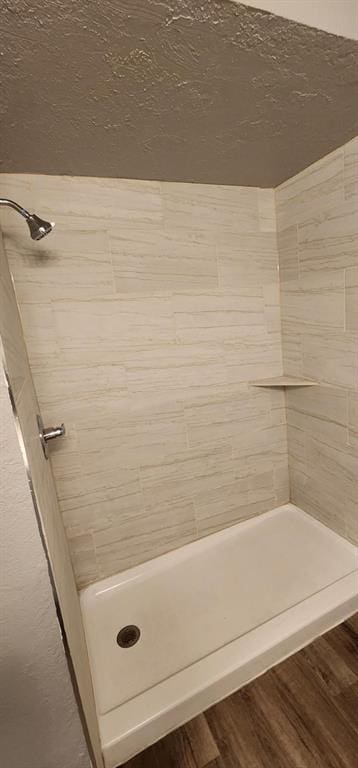 bathroom with hardwood / wood-style floors and a shower