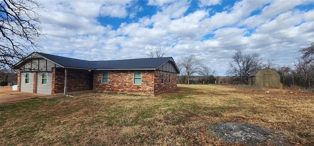 view of side of property featuring a lawn and an outbuilding