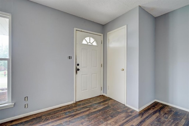 foyer with a textured ceiling and dark wood-type flooring