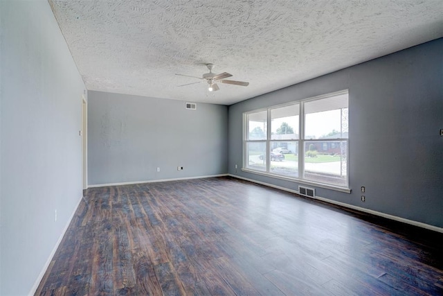 unfurnished room featuring ceiling fan, dark wood-type flooring, and a textured ceiling