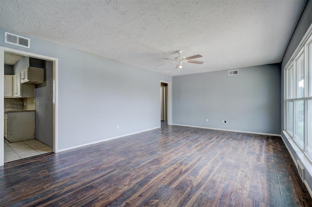 empty room with ceiling fan, light hardwood / wood-style floors, and a textured ceiling