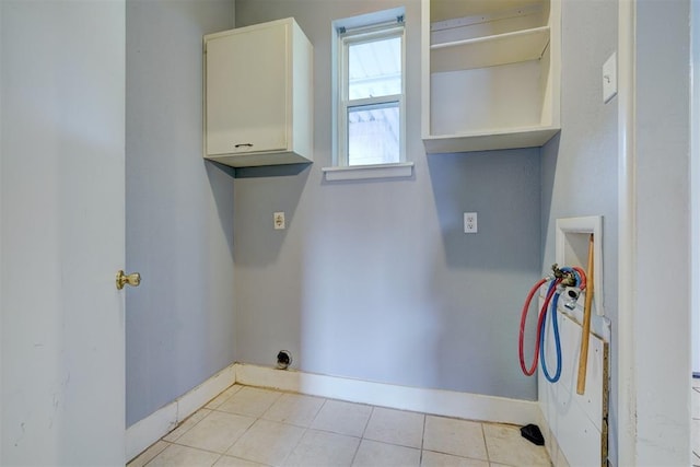 washroom with washer hookup, cabinets, and light tile patterned floors