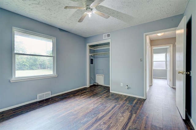 unfurnished bedroom featuring dark hardwood / wood-style flooring, ceiling fan, a closet, and a textured ceiling