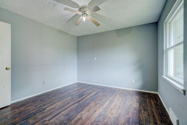 spare room with a textured ceiling, ceiling fan, and dark wood-type flooring