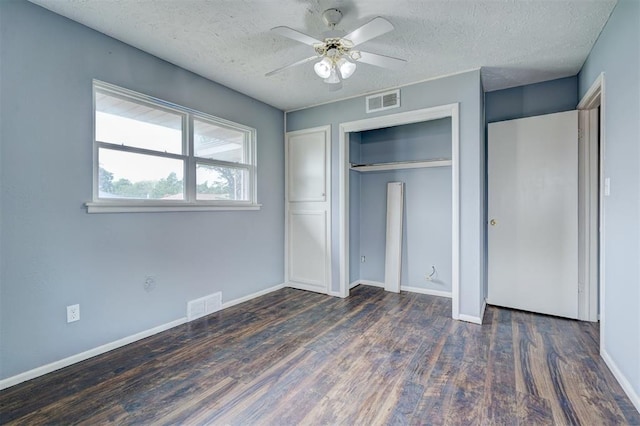 unfurnished bedroom with a textured ceiling, ceiling fan, a closet, and dark hardwood / wood-style floors