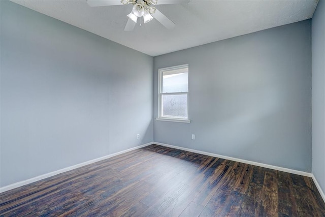 spare room with dark hardwood / wood-style flooring and ceiling fan