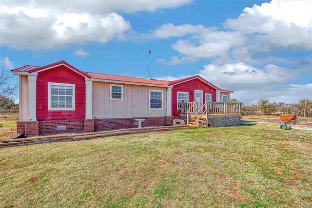 view of front facade with a wooden deck and a front lawn