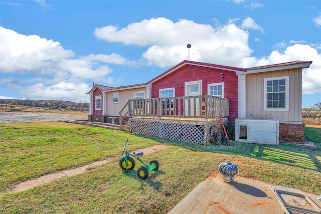 view of front facade with a wooden deck and a front yard