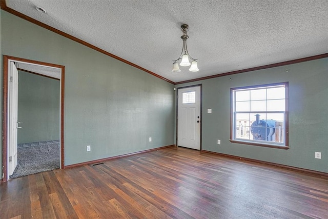 entryway with lofted ceiling, dark wood-type flooring, ornamental molding, and a textured ceiling