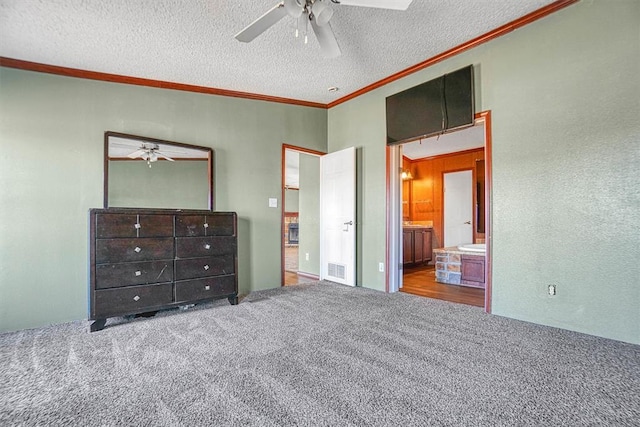 unfurnished bedroom featuring ceiling fan, carpet floors, ensuite bath, and a textured ceiling