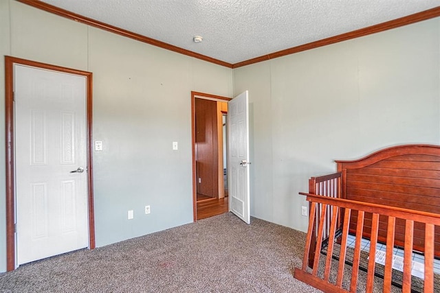 carpeted bedroom with a crib, ornamental molding, and a textured ceiling