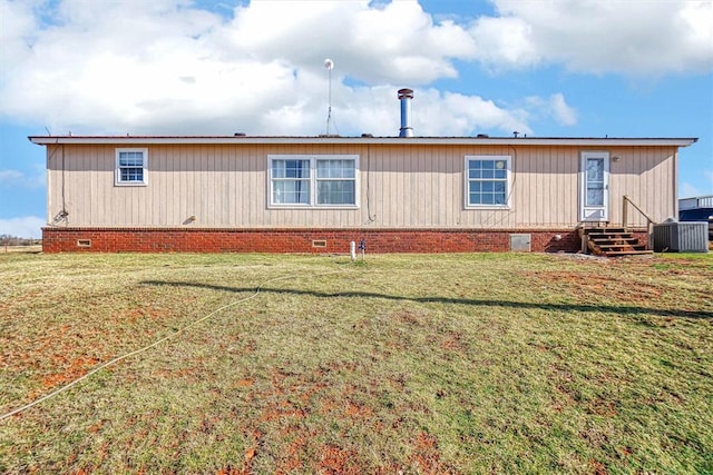 rear view of property featuring central air condition unit and a lawn