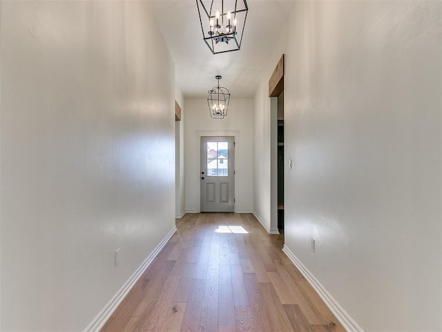 doorway with light hardwood / wood-style floors and an inviting chandelier