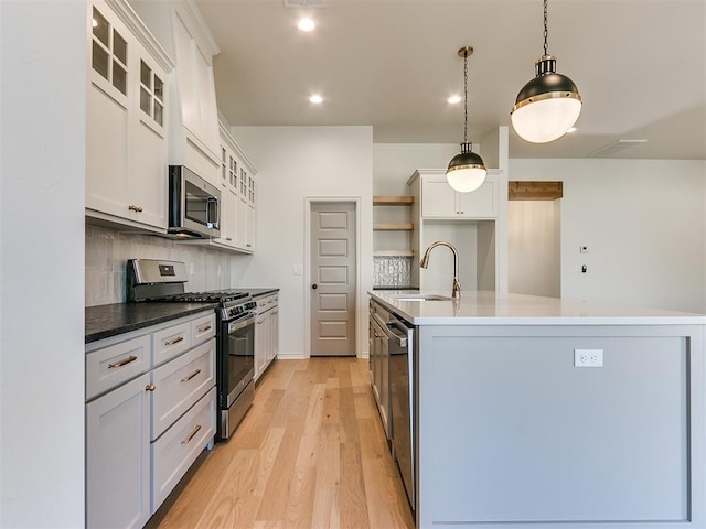 kitchen featuring pendant lighting, sink, white cabinetry, and stainless steel appliances