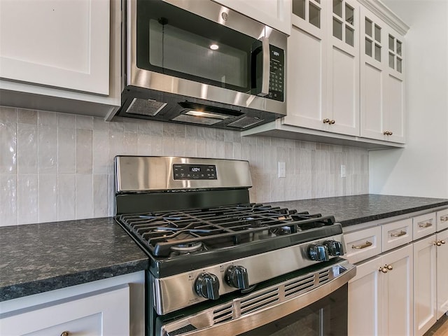 kitchen featuring tasteful backsplash, white cabinetry, and appliances with stainless steel finishes