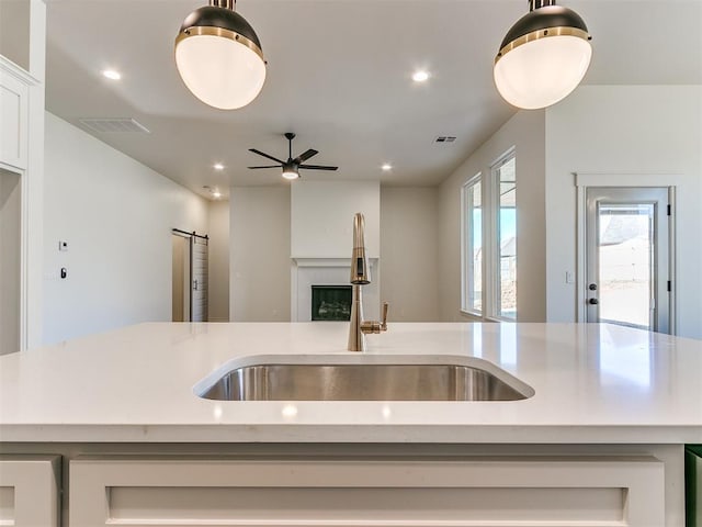 kitchen with a center island with sink, ceiling fan, and sink